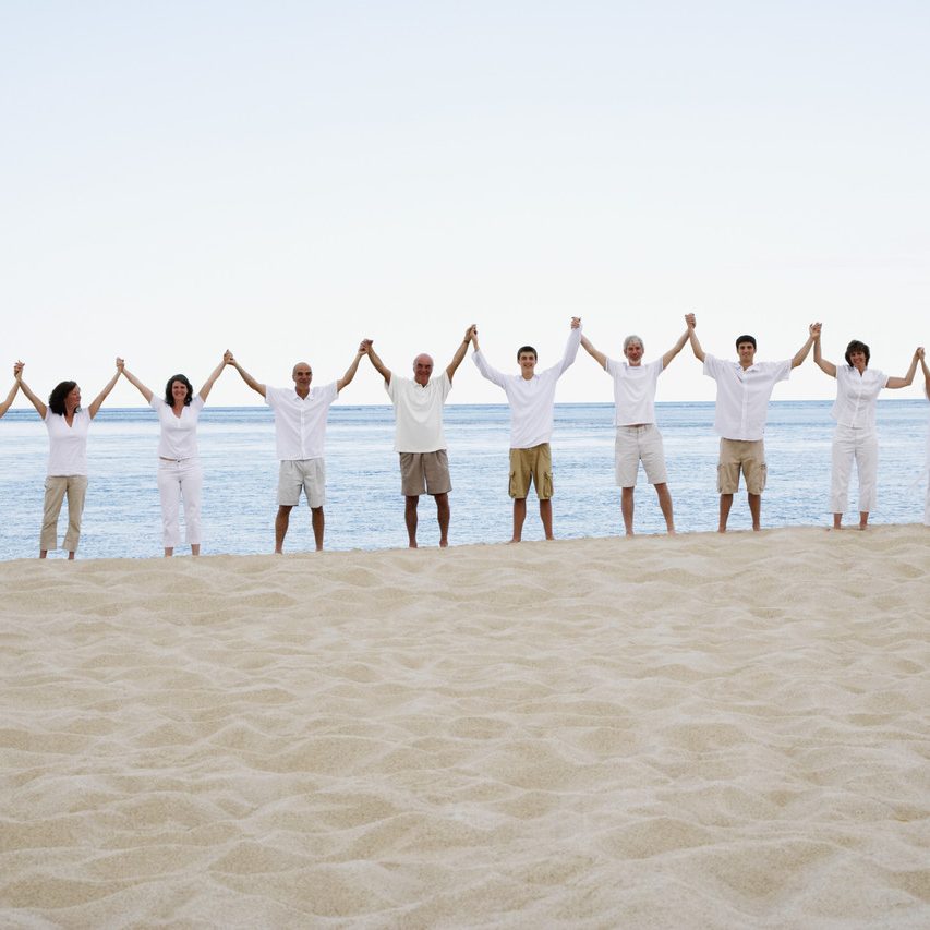 Eine Gruppe von Menschen hält Strand, umgeben von Wasser und Sand. 